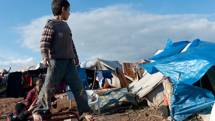 Boy standing in Syrian refugee camp.