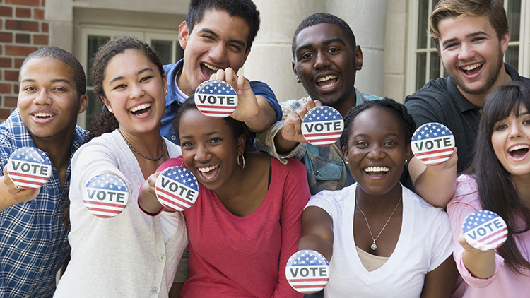 Students holding buttons at voter registration