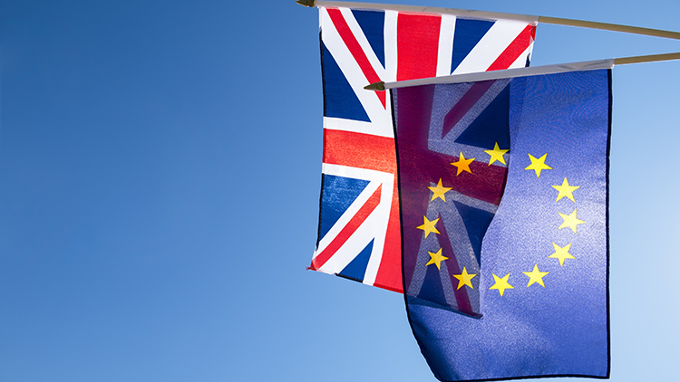 Bandera de la Unión Europea y la Unión Británica Jack volando frente a un cielo azul brillante en preparación para el referéndum Brexit de la UE