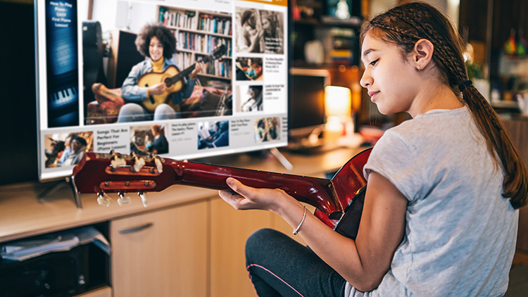 Girl playing a guitar with video online teleconferencing