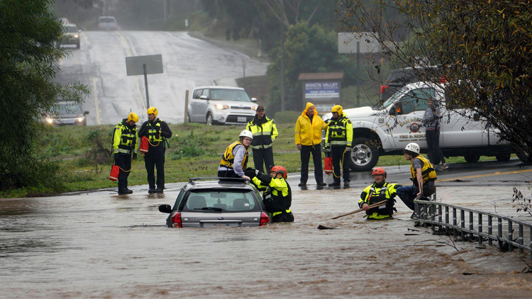 Rescue workers on a flooded street.