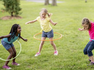 Girls twirling toy hoops around their waists